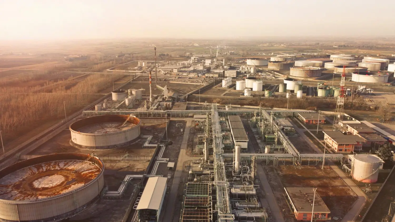 Vista aérea de uma planta petroquímica com tanques de armazenamento e tubulações